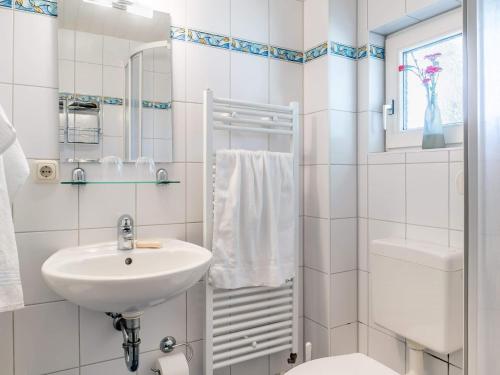 a white bathroom with a sink and a toilet at Seenest Appartement 2 in Zingst