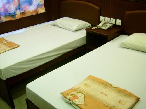 a hotel room with two beds and a phone at Li’s Chain Hostel in Hong Kong