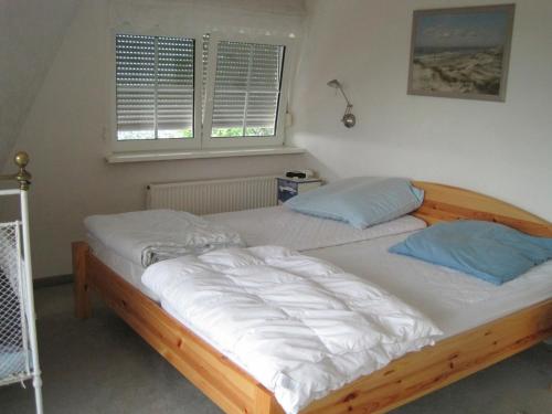 a large bed in a bedroom with two pillows at Ferienhaus Rüder "Schöne Aussicht" in Avendorf auf Fehmarn