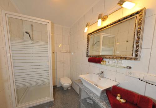 een badkamer met een wastafel, een toilet en een spiegel bij Deluxe Apartments Bremen Typ A in Bremen