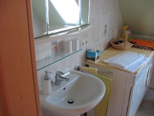 La salle de bains est pourvue d'un lavabo et d'un miroir. dans l'établissement Ferienwohnung Bünz, à Schülp