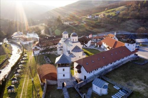 an aerial view of a large white building with a church at Vila ZLATARSKA PAHULJA in Nova Varoš
