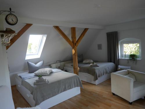 a bedroom with two beds and a chair at Ferienwohnungen im Alten Bahnhof in Osnabrück