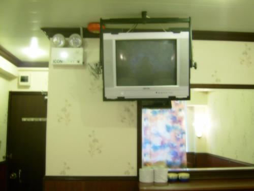 a tv hanging on a wall in a room at Oriental Pearl Budget Hotel in Hong Kong