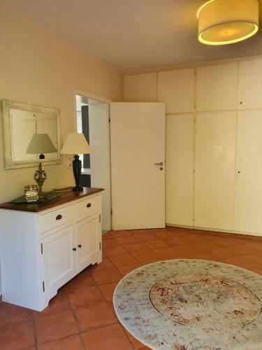 ein Wohnzimmer mit einem weißen Schrank und einem Teppich in der Unterkunft 2 Zimmer Domizil am Südhang mit Terrasse und Pool in Ortenberg