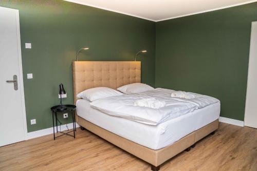 - une chambre avec un grand lit aux murs verts dans l'établissement Gästehaus "Alte Bücherei" Satrup - a50559, à Mittelangeln