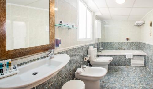 bagno con 2 servizi igienici, lavandino e vasca di Estudios RH Vinaros a Vinarós