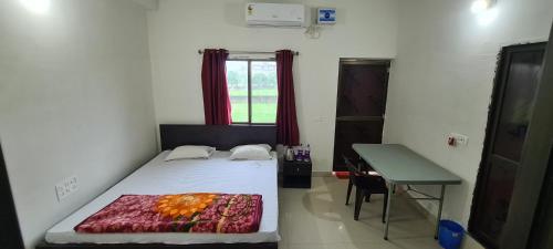 a bedroom with a bed and a desk and a window at Gaurav guest house in Bodh Gaya