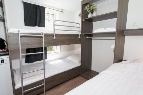 ファルケンスワールトにあるDe Weitens Valkenswaardの二段ベッド2台と窓が備わる客室です。