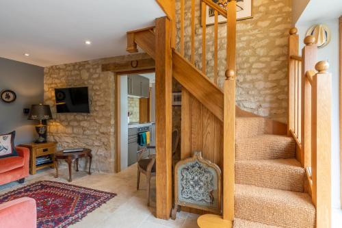 a staircase in a living room with a stone wall at Little Coach House in Beckley
