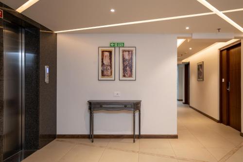 a hallway with a table on a white wall at The Trios Hotel in Cochin