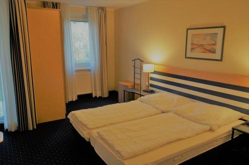 a bedroom with a bed and two tables and a window at Am Kurhaus 410, Villa Kurpark PP 89 in Zingst