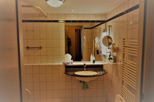 La salle de bains est pourvue d'un lavabo et d'un miroir. dans l'établissement Am Kurhaus 410, Villa Kurpark PP 89, à Zingst