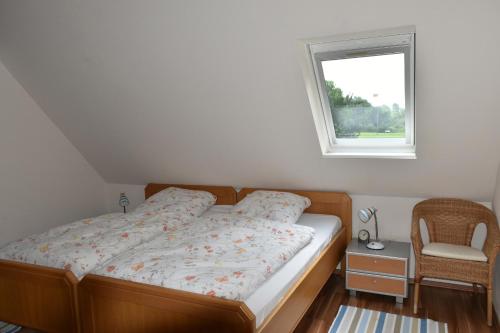 - un lit dans une chambre avec une fenêtre et une chaise dans l'établissement Inselhof Steengrafe - Weserblick, à Schwanewede