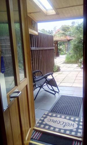 an open door to a porch with a bench at The Steading Highland Glen Lodge in Drumnadrochit
