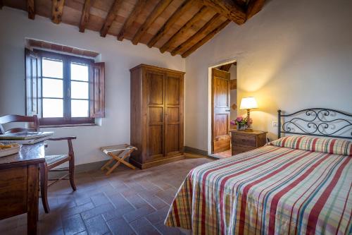 a bedroom with a bed and a desk and a window at Villa S.Andrea in San Casciano in Val di Pesa