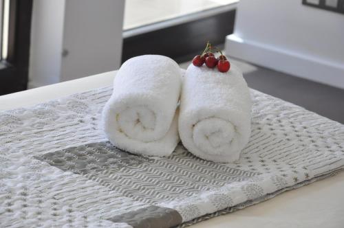 two towels with cherries on them sitting on a bed at Apartament La Placeta Figueres in Figueres