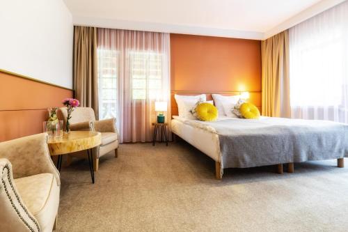 a bedroom with a bed and a couch and a table at Resort Dworzysko in Szczawno-Zdrój