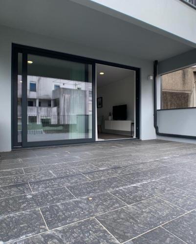 un patio vacío con puertas correderas de cristal en un edificio en PALHOTAS GUEST HOUSE - Apartamento Sé de Braga, en Braga