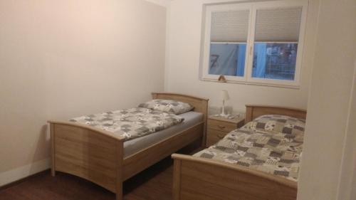 2 camas individuales en una habitación con ventana en FeWo am Uenglinger Tor, en Stendal