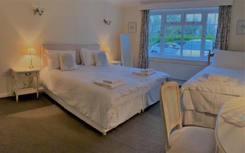 a bedroom with a white bed with a window at Orchard Cottage 