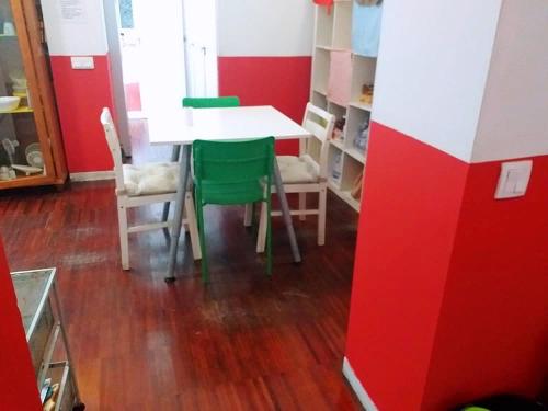 comedor con mesa blanca y sillas verdes en Hostal Casa 18, en Madrid