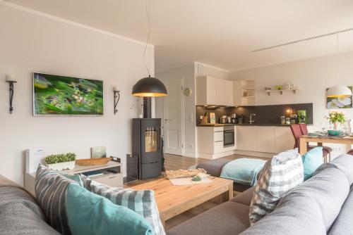 ハイリゲンハーフェンにあるOstsee - Appartement Nr 94 "Luv und Lee" im Strand Resortのリビングルーム(ソファ2台付)、キッチンが備わります。