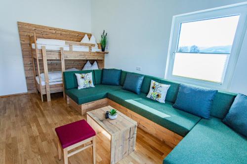 a living room with a blue couch and a bunk bed at Happy Aich 4 by Alpenidyll Apartments in Aich