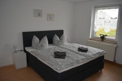 a bedroom with a bed with two black pillows on it at Ferienwohnung am Hainer See in Neukieritzsch