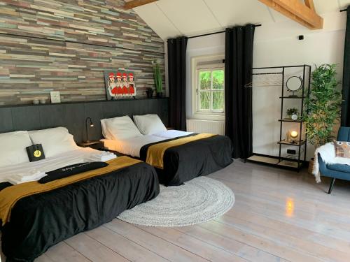 dwa łóżka w pokoju z ceglaną ścianą w obiekcie Sleepzzz w mieście Heusden