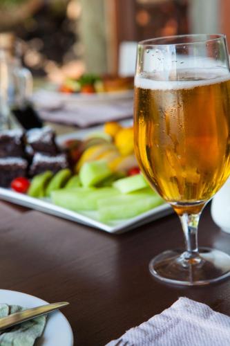 a glass of beer sitting next to a plate of food at Nedile Lodge in Welgevonden Game Reserve