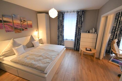 Un dormitorio con una gran cama blanca y una ventana en Zu den Bruchtauen, en Brakel