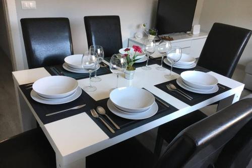 バルセロナにあるsagrada familia gaudiの白いテーブル(椅子、皿、ワイングラス付)