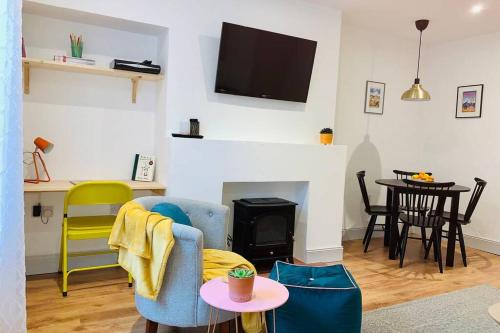 a living room with a couch and a fire place at The Nook - A stylish apartment with garden, near the beach in Berwick-Upon-Tweed