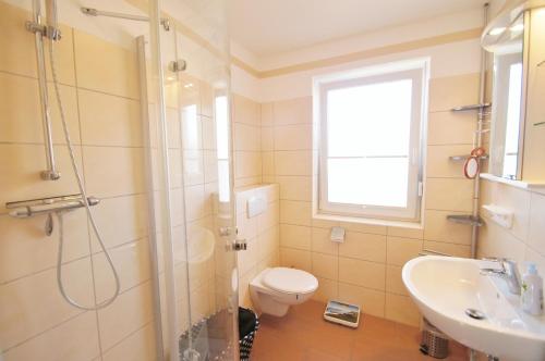 a bathroom with a shower and a toilet and a sink at Huus bi de Kark OG in Dahme