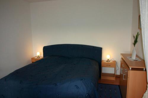 a bedroom with a blue bed and two night stands at Plass, FP I-5-3 in Heiligenhafen