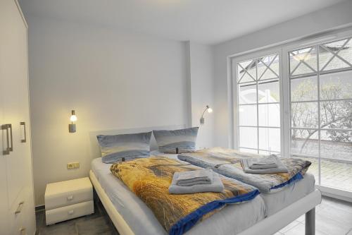a bedroom with a large bed with two towels on it at Villa Obendtied, FW 2 in Zingst