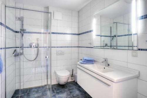 a bathroom with a toilet and a sink and a shower at Villa Obendtied, FW 2 in Zingst