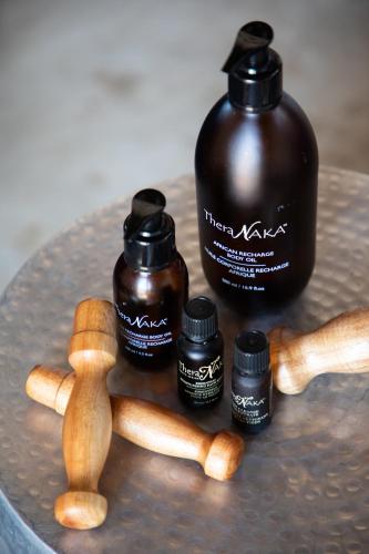 a table with three bottles of honey and wooden sticks at Unembeza Boutique Lodge & Spa in Hoedspruit