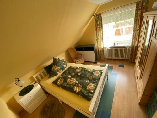 an attic bedroom with a bed and a window at Steinberg-Blick in Herzberg am Harz