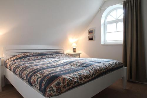 a bed in a bedroom with a window and a bedspread at Residenz Rosenberg FW 3 in Zingst