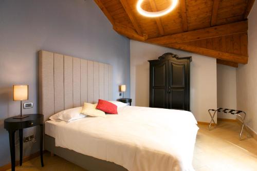 a bedroom with a large white bed with red pillows at Hotel Milano & Apartments in Miazzina