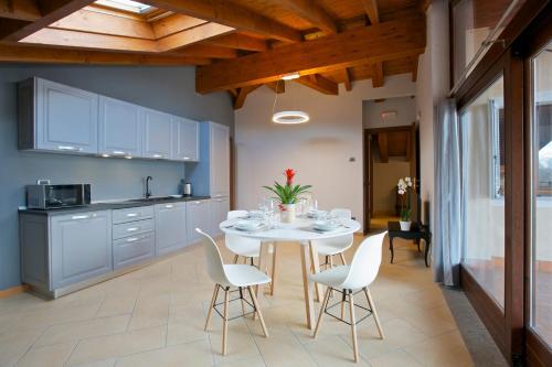 a kitchen with a table and chairs in a kitchen at Hotel Milano & Apartments in Miazzina