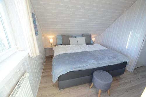 1 dormitorio con 1 cama grande y 1 silla azul en Ferienhaus Wackerama in Gelting, en Gelting