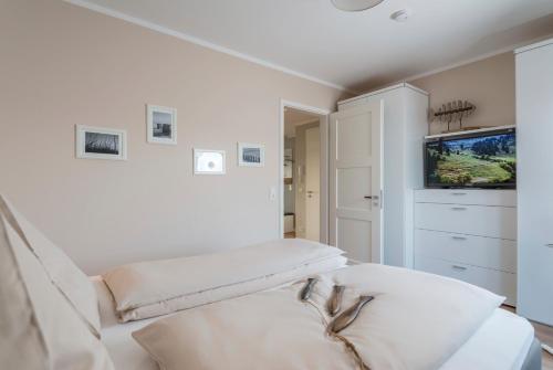 a white room with a couch and a tv at Ostsee - Appartement Nr 152 "11 Ost" im Strand Resort in Heiligenhafen