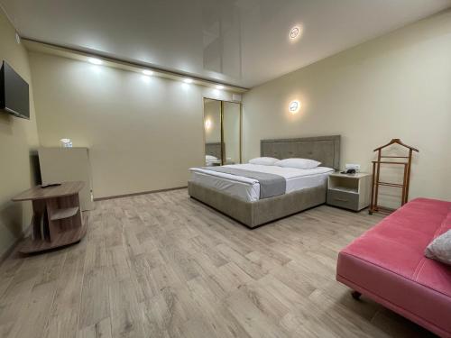 ギュムリにあるCentral Hotel Gyumriのベッドルーム(大型ベッド1台、ピンクのソファ付)