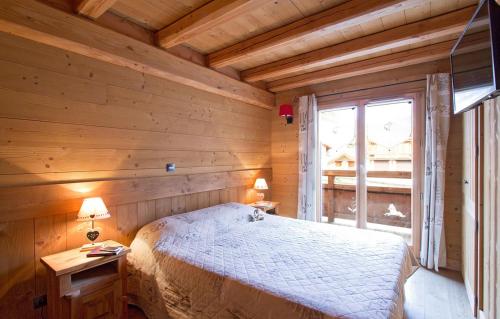 Un dormitorio con una cama en una habitación de madera. en Odalys Chalet Le Loup Lodge, en Les Deux Alpes