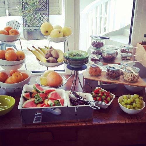 a table topped with bowls of fruits and vegetables at Le Relais Du Lac in Hossegor