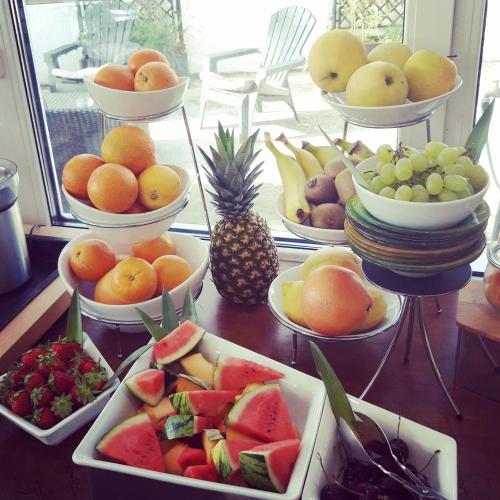 a bunch of bowls of fruit on a table at Le Relais Du Lac in Hossegor