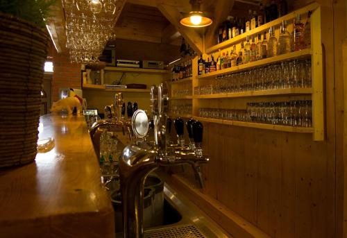 a bar with a counter with glasses on the wall at Domčeky na Ranči in Sučany